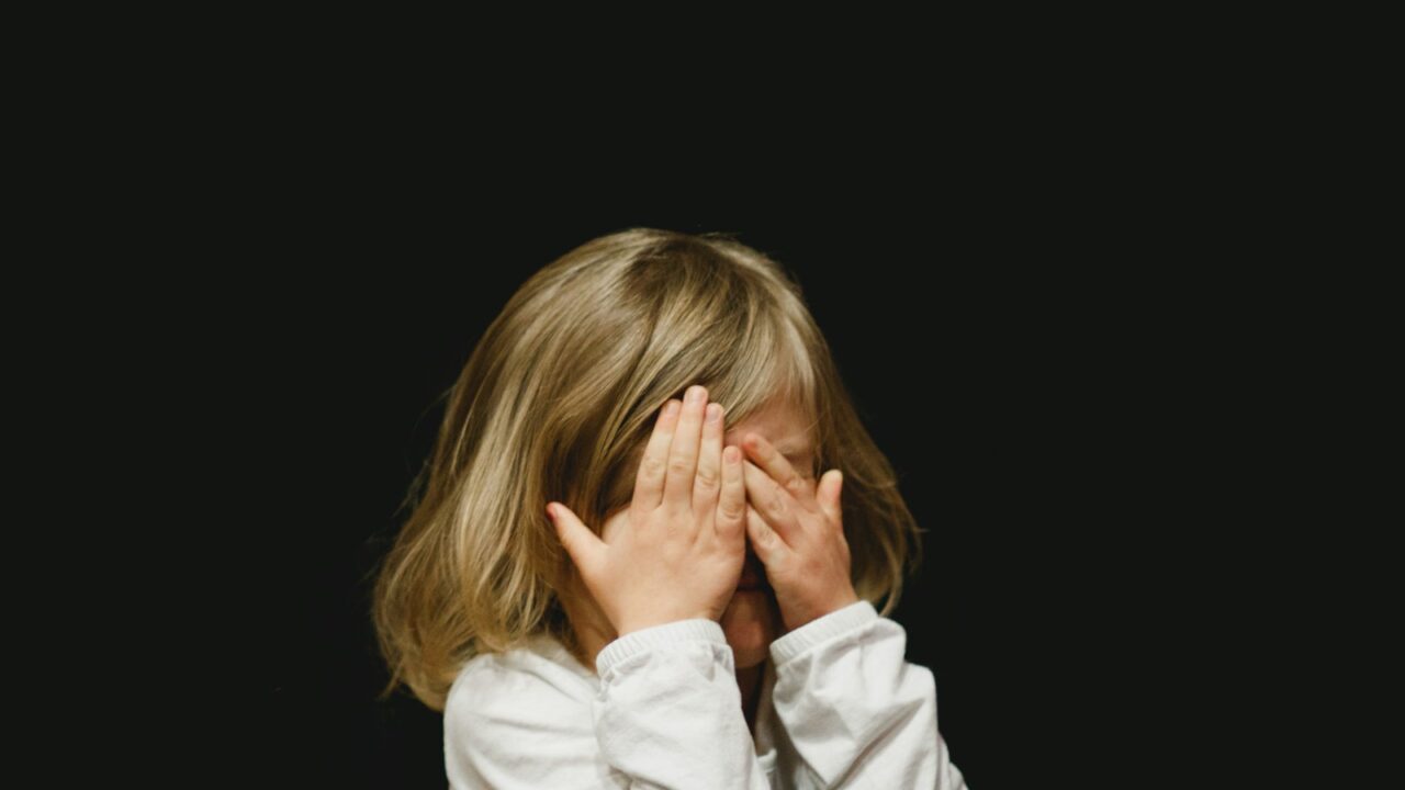 girl covering her face with both hands